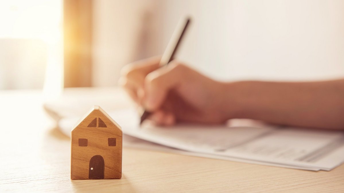 Person plant den Bau eines Hauses anhand von Unterlagen