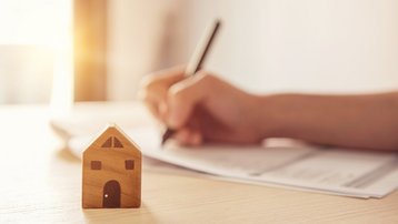 Hausbau sorgfältig planen Person plant den Bau eines Hauses anhand von Unterlagen