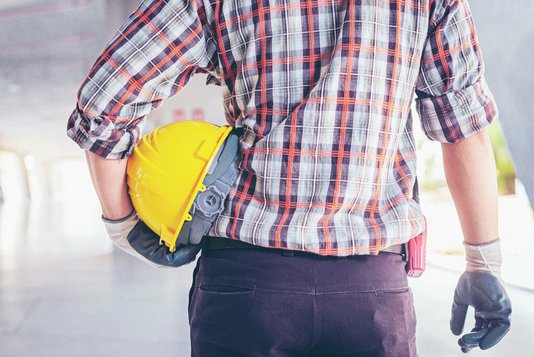 handwerker-arbeiten-am-haus-baustelle-rohbau-14 Handwerker mit Helm und Handschuhen im Inneren einer Baustelle.