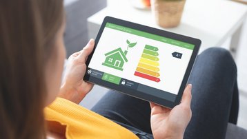 Smart-Home-Energie komfortabel steuern Person steuert Smart-Home-Energieverbrauch über ein Tablet