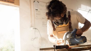 Präzise Handwerksarbeit beim Innenausbau Handwerker bearbeitet ein Holzbrett mit einer Kreissäge