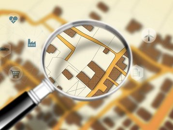 Baugrundstück suchen und Lage prüfen Lupe über Lageplan zur Suche und Prüfung eines geeigneten Baugrundstücks